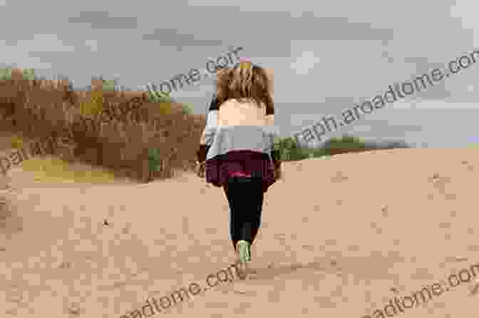 A Woman Sitting Alone On A Sand Dune, Her Gaze Fixed On The Horizon The Long Road Of Sand